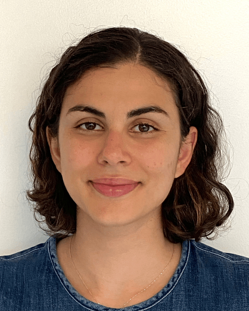Portrait of a woman with short dark hair wearing a denim top, photographed against a plain light background.
